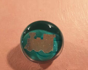 Glass paperweight button showing a train.