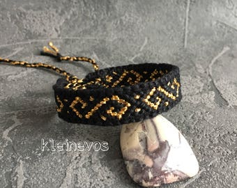 Knotted bracelet in black with a shiny golden swirl