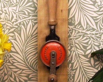 Vintage carpenters hand drill mounted as coat rack.