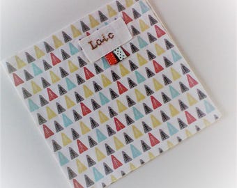 Serviette de table enfant ,personnalisable ,serviette de cantine,coton représentant des petits sapins multicolores sur fond blanc .