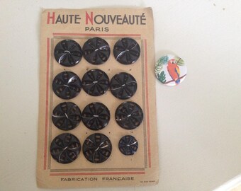 Old plate of 12 black buttons