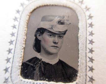 antique tintype with paper frame - young woman, rosy cheeks, hat