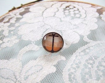 Round cabochon ring anchor on orange background