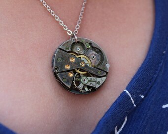 Unique vintage victorian steampunk recycled upcycled and clock parts costume jewlery necklace with exposed gears in gold and silver tones.