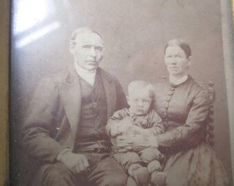 Old photo of wife, husband and baby. Small picture in frame.