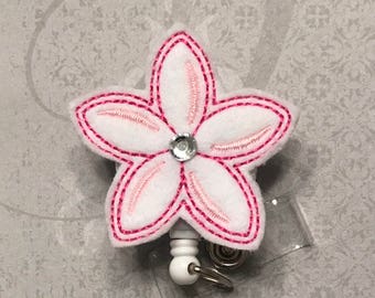 White and pink flower badge reel