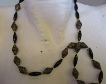 vintage goldtone metal black bead necklace with fancy black/gold patterned exotic bead