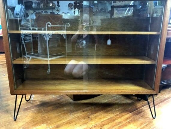 Mid century bookcase with sliding glass doors and hairpin legs