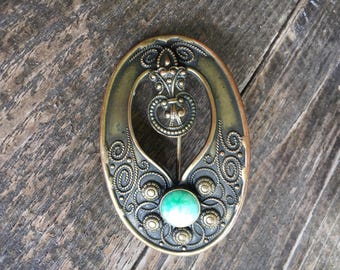 Antique Art Nouveau Sash Pin. Cira 1890's = Pre W.W.1 . Brass metal . Green Glass Cabochon. Period pin closure .