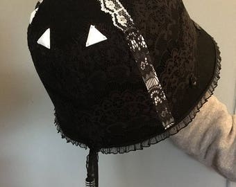 Black cloche hat with white details.