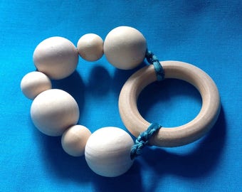 Wooden rattle and teether in her pouch.
