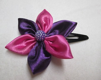 A pink and purple satin flower hair clip