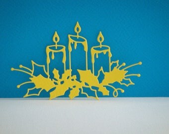 Cut out of 3 candles on yellow Holly leaves
