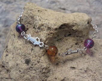 Silver plated bracelet with four skeletons of fish and beads.