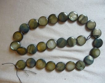 Beads, Mother of Pearl 15mm Flat Round Coin, Shades of green. Sold per 15 inch strand. There are 28 beads on the strand.