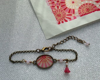 Bracelet, pink and white geometric patterned paper.