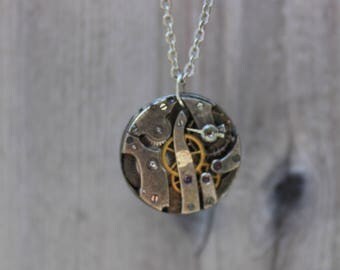Unique vintage victorian steampunk recycled upcycled and clock parts costume jewlery necklace with exposed gears in gold and silver tones.