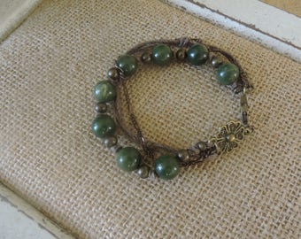 Green and bronze triple strand. Lovely bronze medallion by the lobster clasp. 8"