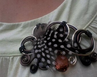 Brooch is black and brown feathers and Pearl