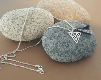silver necklace with triangular pendant and tassel