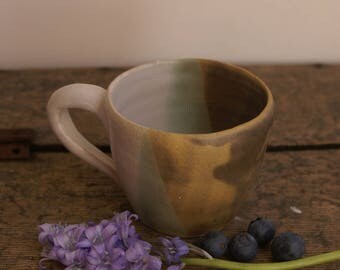 Hand thrown mug with grey and white glaze and rawpot areas