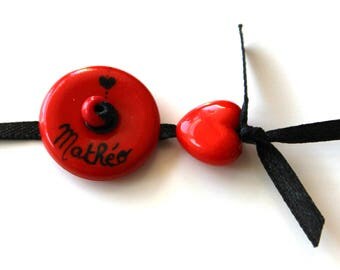 Personalized name bracelet a red medallion and red heart