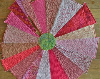 Round decorative wall quilt in shades of pink