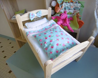 Small wooden doll bed and bed linens