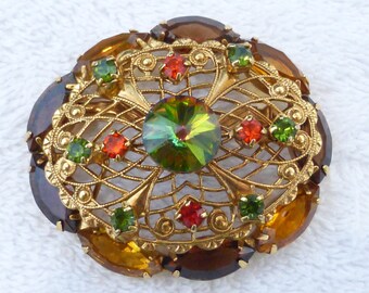 Oval dome brooch with gold tone filigree, rhinestones and watermelon rivoli AB89
