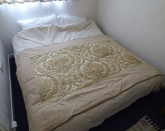 A wholecloth quilt with a floral pattern. Brown,green and cream. Bed runner, single topper, lap quilt or sofa throw. Handquilted.