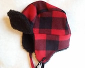 Toddler trapper hat fits up to 18 inches around. Made of fleece and polyester fur lining with fleece ties. Flaps can be worn up or down