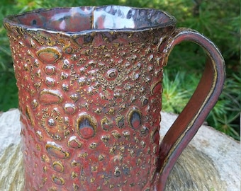 Handmade pottery mug textured with lace and glazed in Ancient Jasper