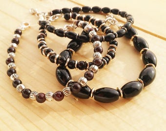 Bracelets by a thread with glossy black glass beads