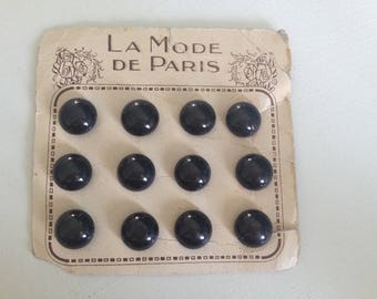 Old plate of 12 black buttons