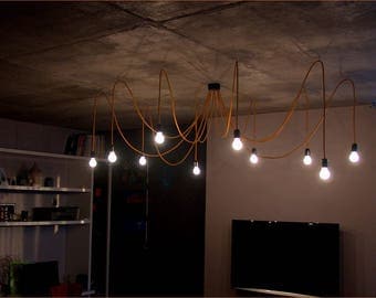 Golden chandelier with twelve textile cables. Ceiling octopus or spider.