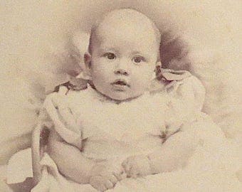 Cabinet card, antique. Featuring a baby with an alert expression. J. Fisher, 90 Golborne Rd. North Kensington. 1890's.