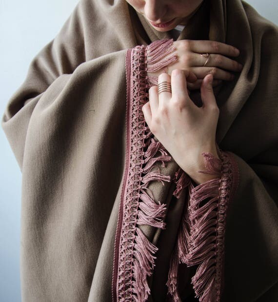 Pale rose throw blanket with matching tassels.