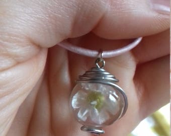Pendant with flower inside transparent sphere