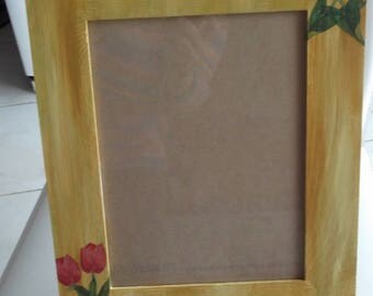 Photo frame with spring tulips on yellow background