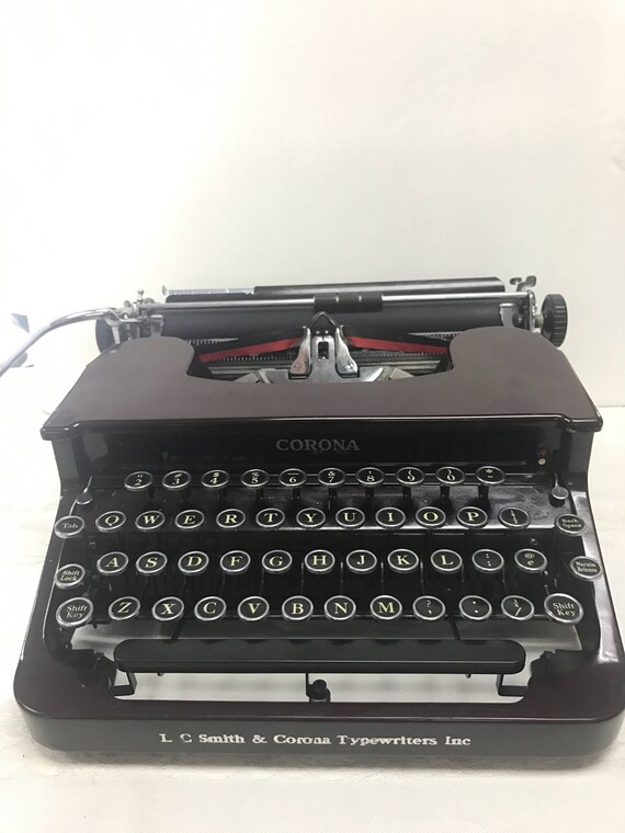 Maroon portable typewriter by smith & corona