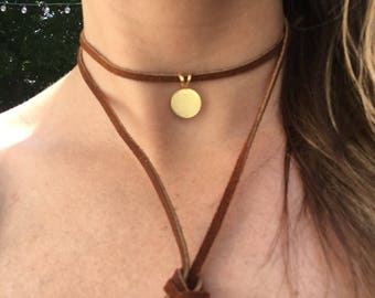 Genuine leather wrap necklace with a gold circle pendant and bronze bolo tips