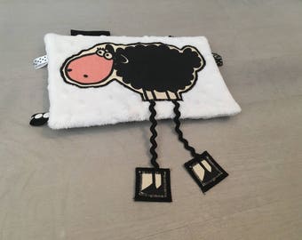 Black and white sheep cuddly with long legs
