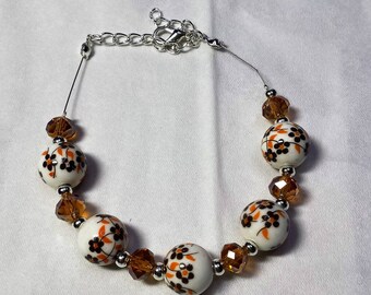 Cable bracelet brown/orange porcelain beads