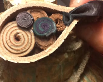 Leather pendant with concentric circle patter and swirl symbols and earthy boho style