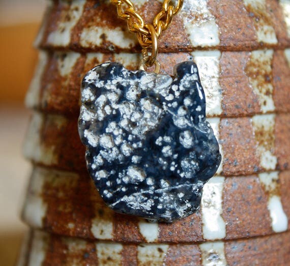 Natural Black Stone With White Spots On Gold Colored Chain.