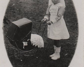 Carnival costume, girl as nanny, antique doll pram, antique snapshot, fancy dress, postcard, Fayre, social history, vernacular (rppc/ch477)